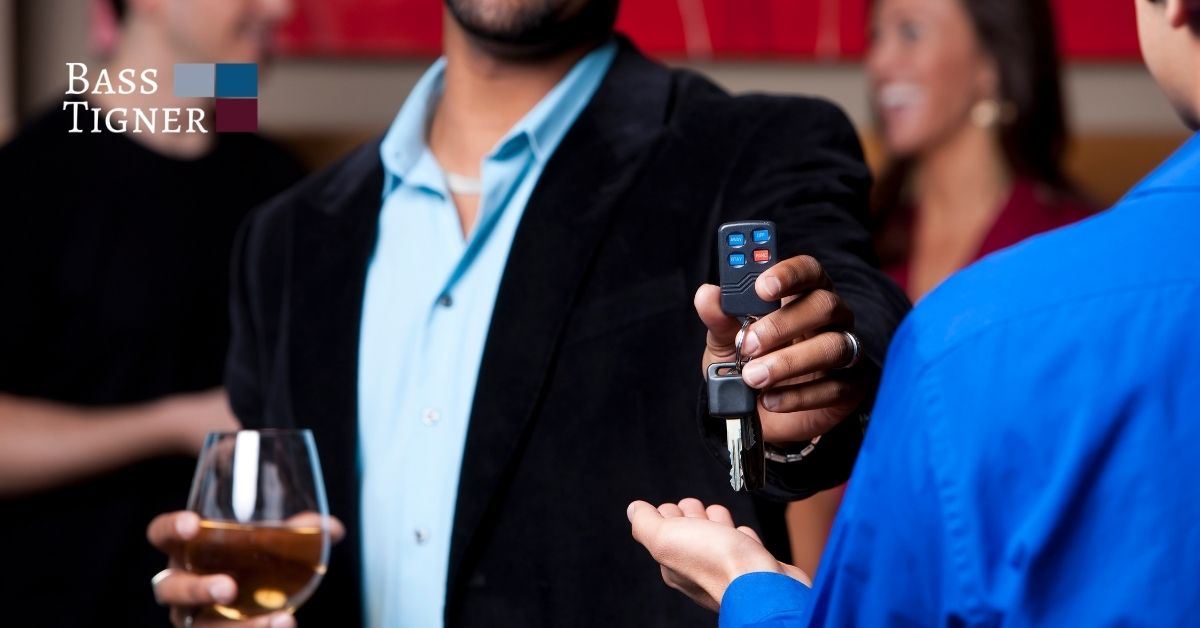 Man holding a drink and keys.
