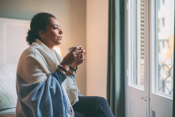 Sad woman drinking coffee looking out the window