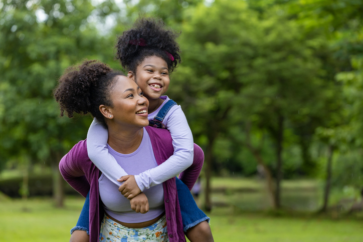 mother giving daughter piggyback ride