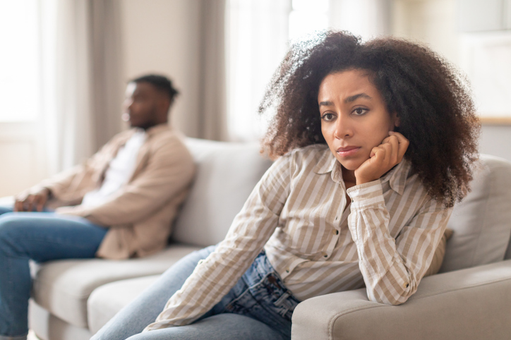 couple in a fight sitting on their couch